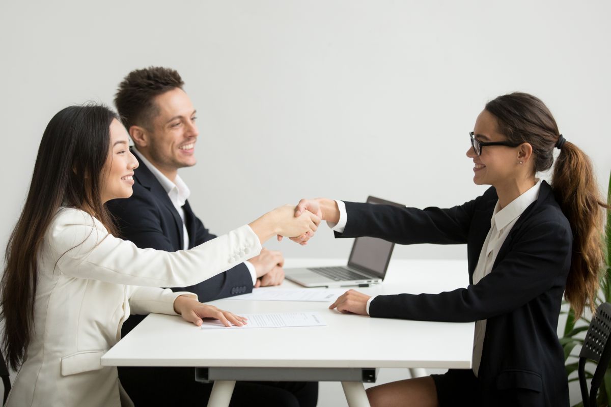 smiling-diverse-businesswomen-shake-hands-group-meeting-deal-concept(1)